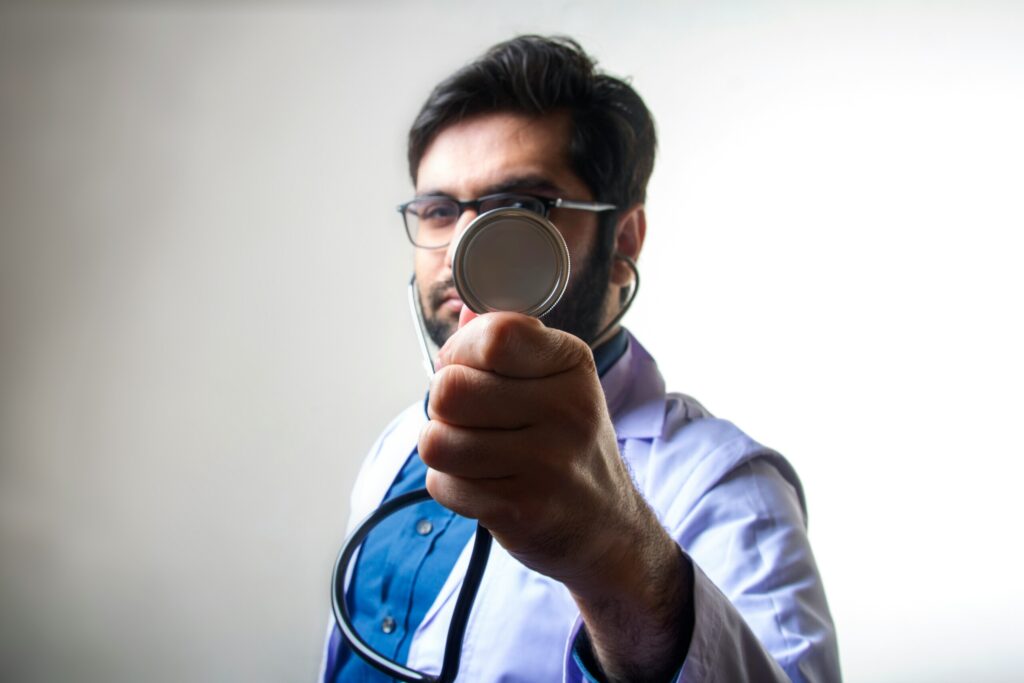 male physician holding up a stehoscope